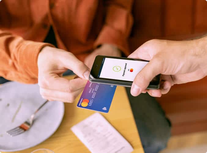Un client paie avec une carte bancaire sans contact sur un Famoco FX105, équipé de Famoco Pay